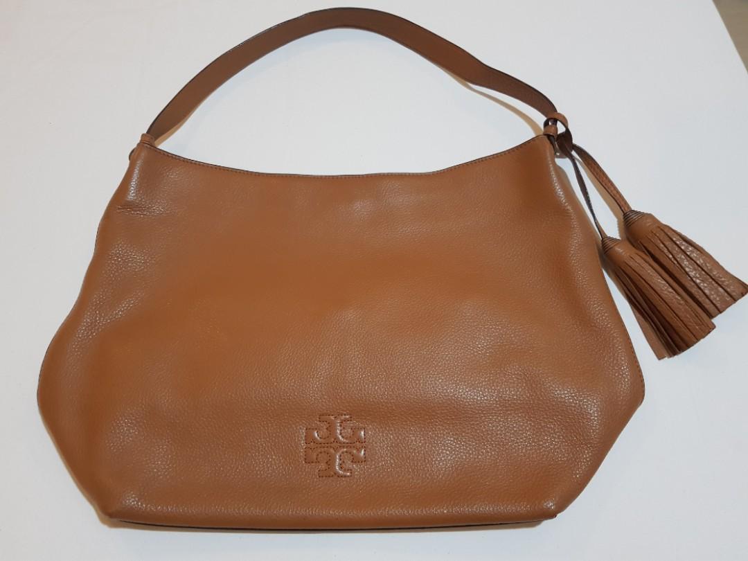 Original/authentic Tory Burch Thea Hobo (Category: Luxury Bags & Wallets) located in Makati City. Submitted by B_man (Listing ID 1174240734, Image 1). Description: Leather Hobo Handbag. Dimensions:approx 10.5 in (H) x 15.5in (L) x 5.5in (bottom W). with a magnetic snap closure, an interior zip pocket, two exterior slip pockets, one buttoned interiorpocket and decorative tassels..