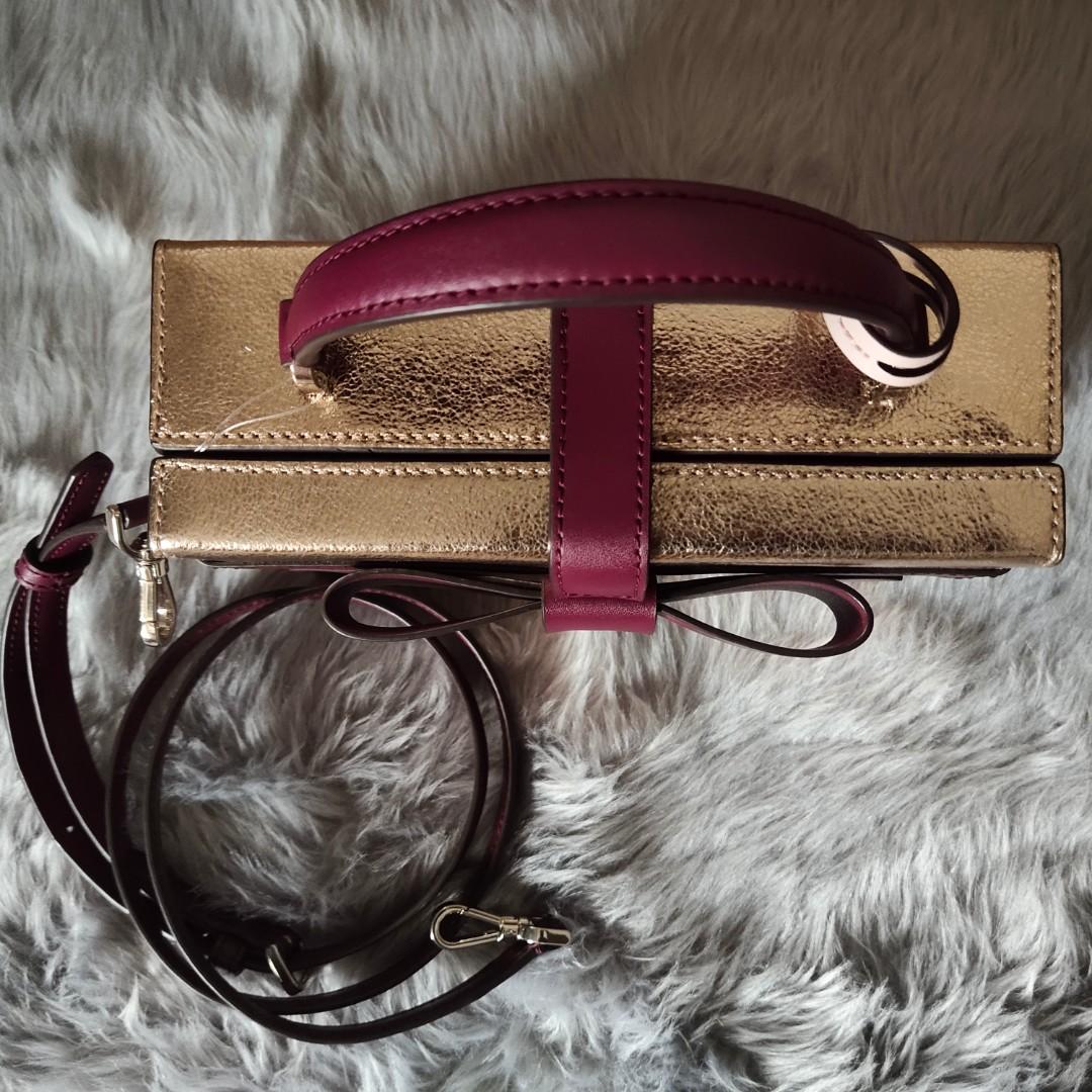 Kate Spade ribbon top handle bag (Category: Luxury Bags & Wallets) located in Santa Cruz. Submitted by phkashoppe (Listing ID 1178336150, Image 2). Description: authentic Kate Spade vanity bag with bow design brand new with tag and care card with detachable/adjustable sling shiny rose gold leather with maroon leather ribbon design gold hardware.