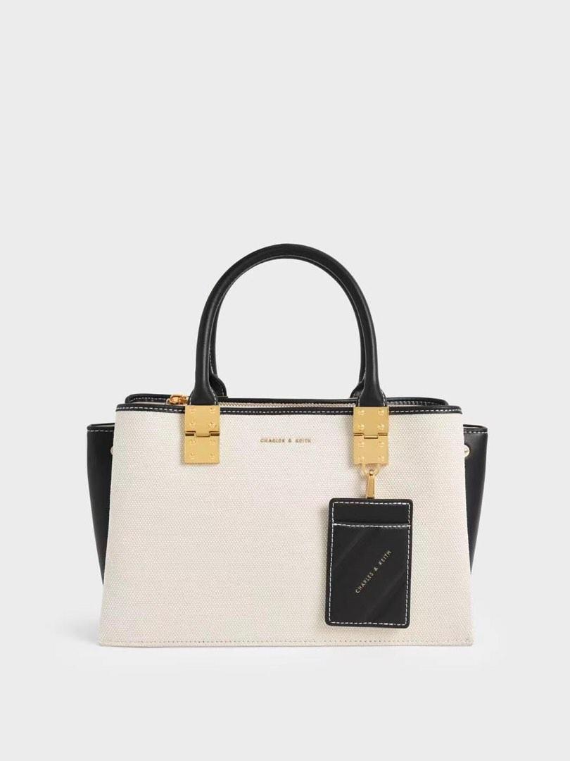 Charles & Keith Double Top Handle Structured Crossbody (Category: Cross-body Bags) located in Manila. Submitted by chic.collectivemnl (Listing ID 1182826365, Image 1). Description: Charles & Keith Double Top Handle Structured Crossbody Size: 30x12x18cm Colors: ultra black, light pink Price: 1,250 only!.