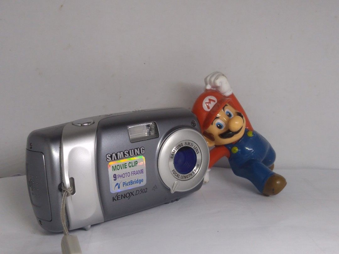 Samsung vintage camera (Category: Cameras) located in Las Pinas. Submitted by film101 (Listing ID 1208891826, Image 2). Description: 🌟Samsung Kenox D502 ✨Known as DIGIMAX 502 ✨5MP ✨With time stamp ✨Imptd purchase 🔹Its stylish and vintage style camera, its a smaller and compact type digital camera 🔹Still/videos 🔹Inclusion:orig samsung pouch, straps, memory card 256MB,card reader 🔺Batt AAx 2pcs not included ✨Condition of camera✨ 🔸Flash workin