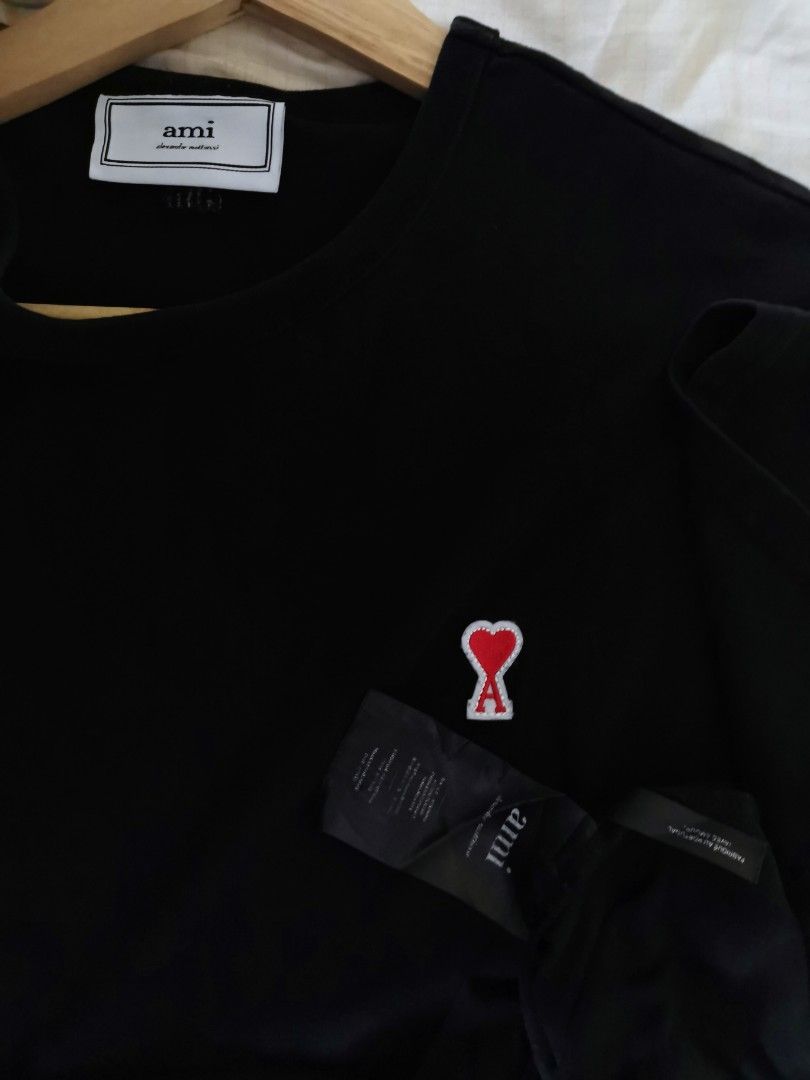 Ami A Heart Patch Logo Black Tee (Category: Luxury Apparel) located in Makati City. Submitted by _collectorschoice_ (Listing ID 1211439903, Image 3). Description: ° Parisian label AMI decorates this black tee with its iconic Ami de Cœur motif ° Made in Portugal from pure cotton jersey ° The short sleeved style is completed with a comfortable ribbed neckline ° Tonal Ami de Cœur embroidery ° Tonal AMI embroidery under back neckline ° Appliqué brand