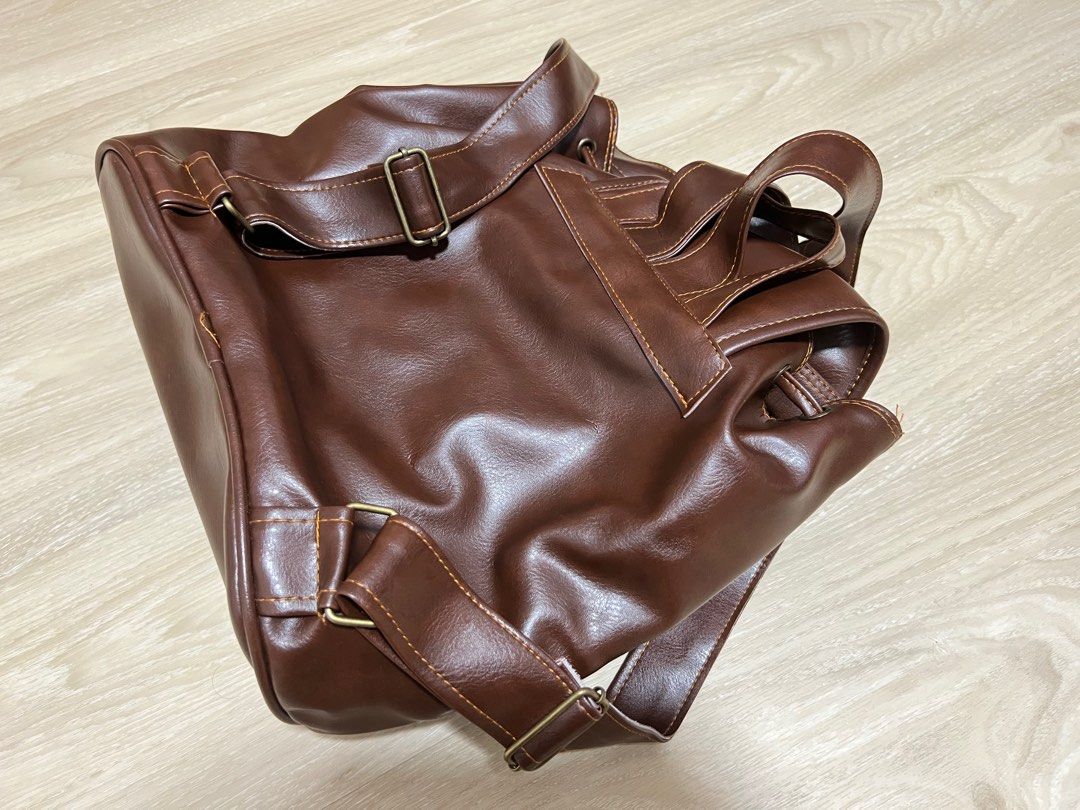 Small backpack (Category: Backpacks) located in Singapore. Submitted by pigami (Listing ID 1211744940, Image 3). Description: Details: •Measurement: 28Lx17W(Base)x29H •Made in Thailand •Soft feel even though PVC, well constructed brown bag (colour is dark brown, more accurate in 2nd pic) •One internal pocket •Brand new in plastic bag Self collect at Postal code 322004.