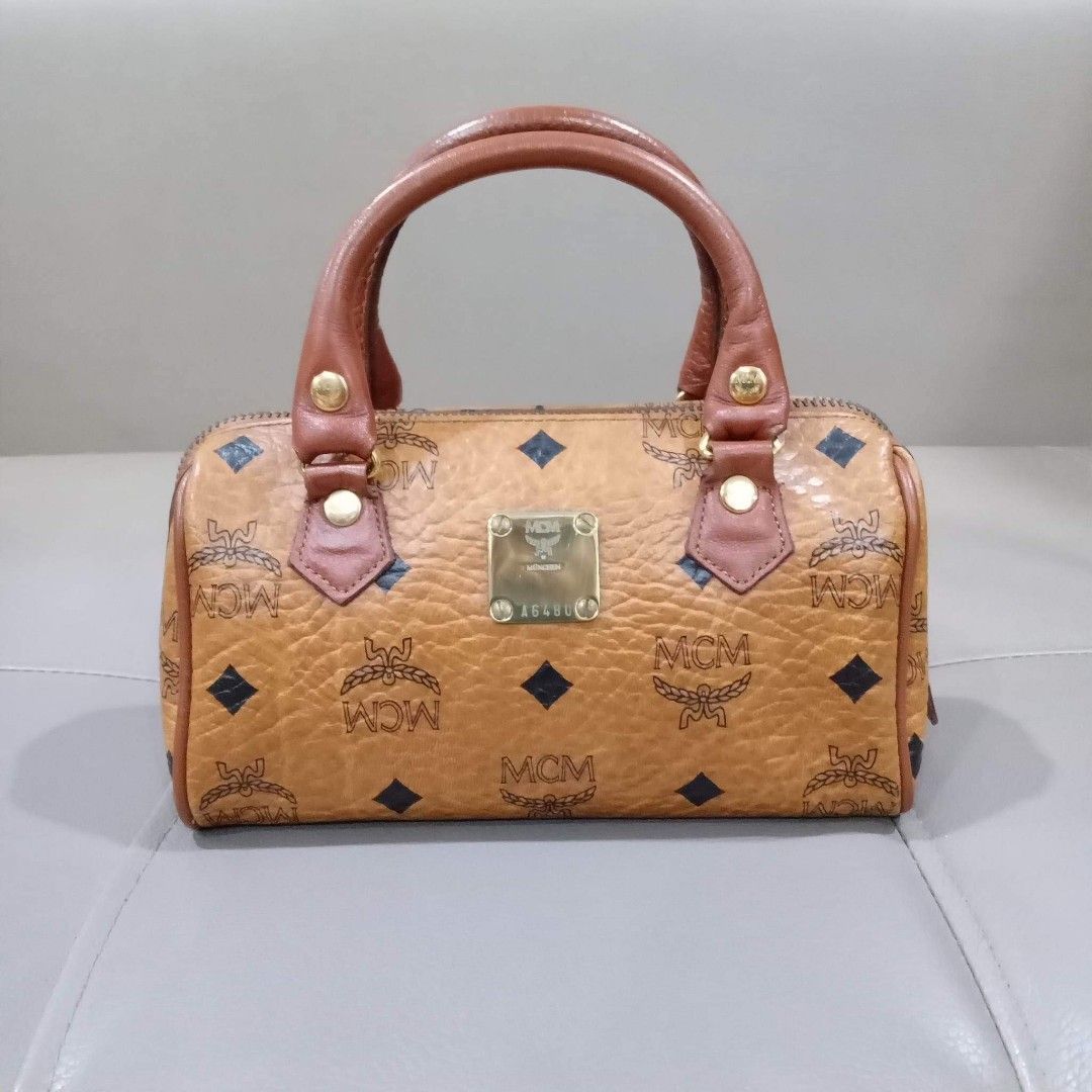 MCM Mini Boston Cognac Sling Bag (Category: Luxury Bags & Wallets) located in Taguig. Submitted by esa.agustin (Listing ID 1207328199, Image 2). Description: Original MCM cognac pvc leather mini boston sling bag. Size 18 cm. Made in Germany..