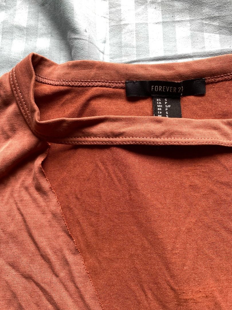Forever 21 cutout shirt (Category: Shirts) located in Pasig City. Submitted by hello__ivy (Listing ID 1207530915, Image 2). Description: Forever 21 top with cutout neck area Rust color Soft material Unused Size S on tag but fits til M 🛵 Shipping via Grab or Lalamove (arranged by buyer) 📍 Cainta pick-up point 💵 MOP: Gcash / BDO / BPI.