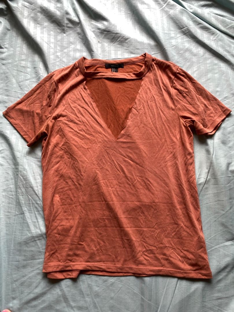 Forever 21 cutout shirt (Category: Shirts) located in Pasig City. Submitted by hello__ivy (Listing ID 1207530915, Image 1). Description: Forever 21 top with cutout neck area Rust color Soft material Unused Size S on tag but fits til M 🛵 Shipping via Grab or Lalamove (arranged by buyer) 📍 Cainta pick-up point 💵 MOP: Gcash / BDO / BPI.