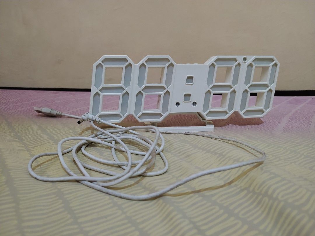 White 3D LED Digital Essential Modern Clock (Category: Clocks) located in Pasig City. Submitted by therainbowcorner (Listing ID 1259511366, Image 2). Description: Can also be hanged on the wall. Features includes: Time Date Alarm Temp length 9" long height 3.6" cord needs cleaning.