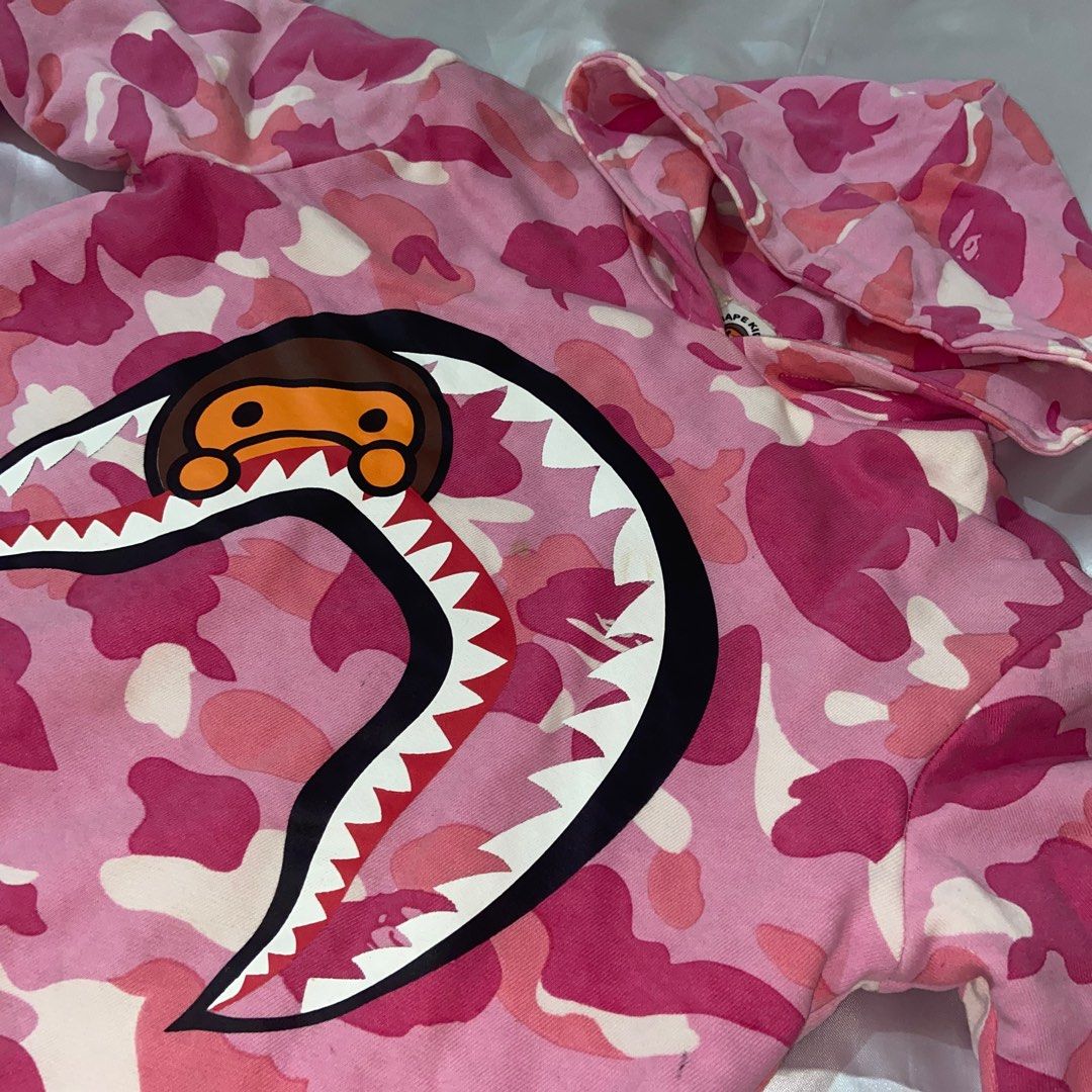 BAPE Pink Camou Hoodie (Category: Coats, Jackets and Outerwear) located in Cavite. Submitted by ginalinettilover1 (Listing ID 1261477218, Image 1). Description: rfs: need funds :) AUTH 💯!!! it’s a kid’s size (160) but it fits small body frames. swipe for ww photos :) 10/10 CONDITION!!! NO FLAWS AT ALL. this hoodie is double lined so it’s really comfy <33.