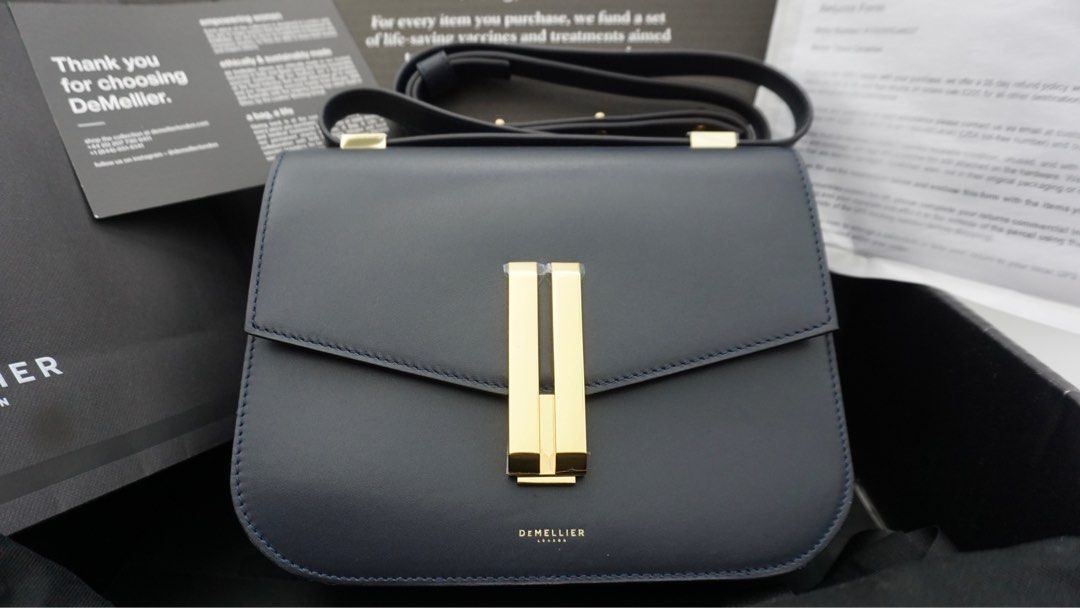 DeMellier Vancouver navy smooth (Category: Luxury Bags & Wallets) located in Manila. Submitted by samwear (Listing ID 1238521289, Image 1). Description: -Slightly used with hardware wrap -Bought personally in UK (I can provide screenshot of receipt) -dust bag, paper bag included -Quiet Luxury 💯 Top Width: 23cm/9” Base Width: 23cm/9” Height: 18cm/7” Depth: 7cm/3” Min. Strap Length: 106cm/42” Max. Strap Length: 116cm/45” Weight: 600g Devices: This