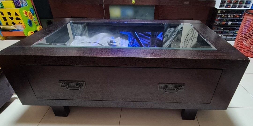 Solid wood coffee table (Category: Tables & Sets) located in Singapore. Submitted by hhquek (Listing ID 1265308243, Image 1). Description: Very sturdy and functional. Dimension: L 110cm x W 72cm x H 39.5cm Has 4 internal compartments so can store many things below or you can display items as a showcase. Each compartment is L 43cm x W 32cm x H 10cm.