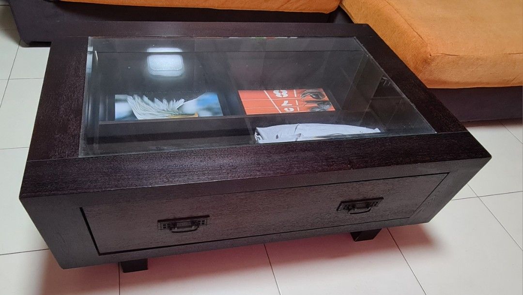Solid wood coffee table (Category: Tables & Sets) located in Singapore. Submitted by hhquek (Listing ID 1265308243, Image 3). Description: Very sturdy and functional. Dimension: L 110cm x W 72cm x H 39.5cm Has 4 internal compartments so can store many things below or you can display items as a showcase. Each compartment is L 43cm x W 32cm x H 10cm.