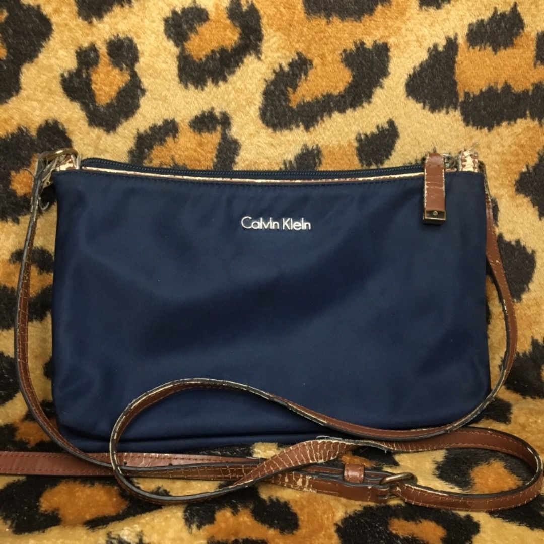 TWO SLING BAGS FOR ONE PRICE (Category: Cross-body Bags) located in Naga. Submitted by clayjay (Listing ID 1266785348, Image 1). Description: CALVIN KLEIN AND LONGCHAMP SLING BAGS with emblem (calvin klein) outside and logo prints inside the bag (need lang din labhan and ibrush yung inside kasi nastock) CALVIN KLEIN: straps are already peeling but the bag itself still looks like new LONGCHAMP: broken zipper but the bag itself still looks like new