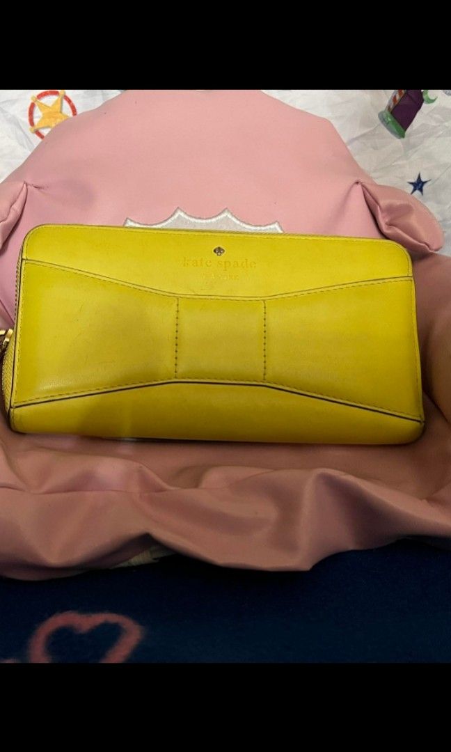 Kate Spade Yellow bow wallet (Category: Luxury Bags & Wallets) located in Quezon City. Submitted by uptrendglam (Listing ID 1267081443, Image 1). Description: Kate Spade light yellow bow wallet only issue is needs cleaningon the exterior side (check pics). RFS : Decluttering.