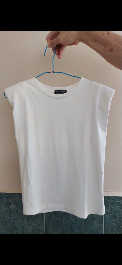 White top (Category: Sleeveless) located in Singapore. Submitted by whatyoudontneed (Listing ID 1267166310, Image 1). Description: brand new, never worn before. plain white top with shoulder pads.
