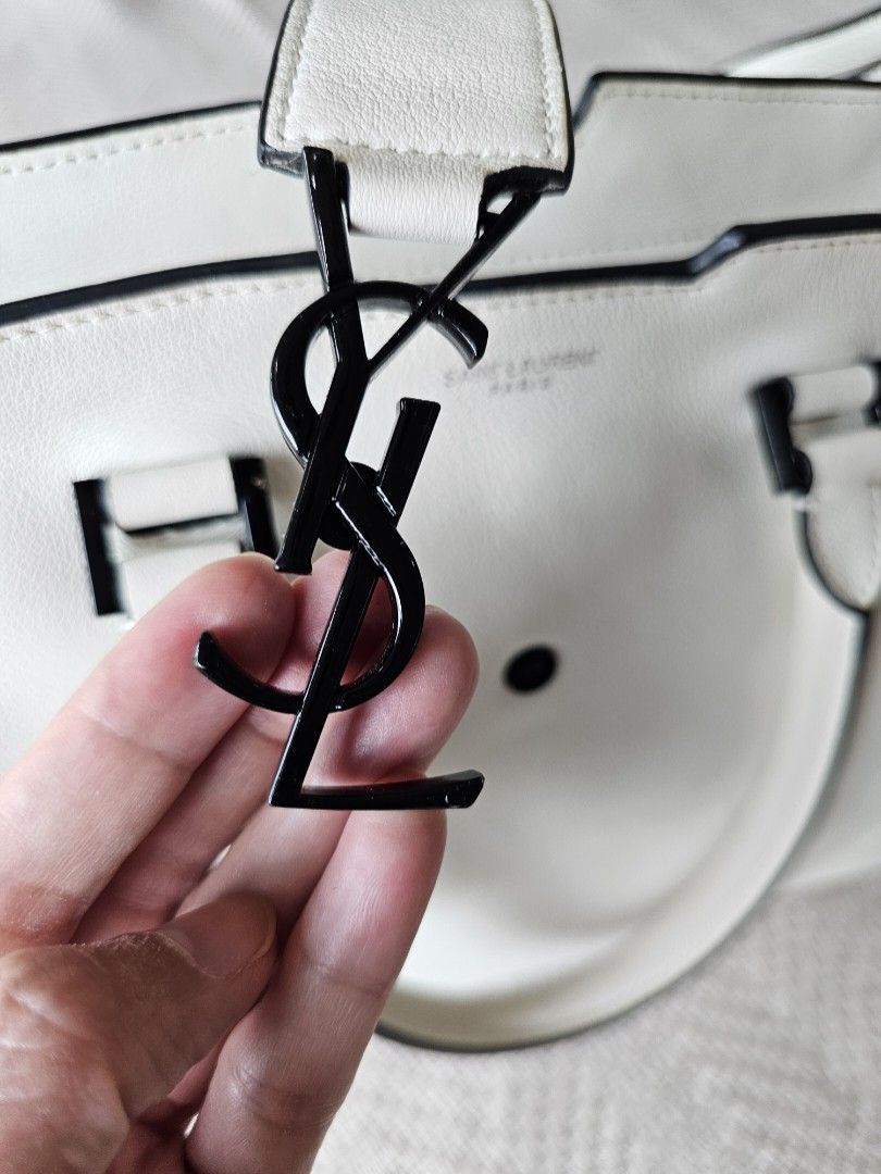 YSL Downtown Cabas Handbag white (Category: Luxury Bags & Wallets) located in Mandaluyong City. Submitted by elizadoolittl (Listing ID 1267085044, Image 3). Description: YSL Downtown Cabas handbag in white soft leather. Used only a few times. There are some small and hardly noticeable dirt on the outer leather (shown in photos), a speck of stain on the corner of the front handle, and a small streak of light blue pen ink near the zipper. Other tha