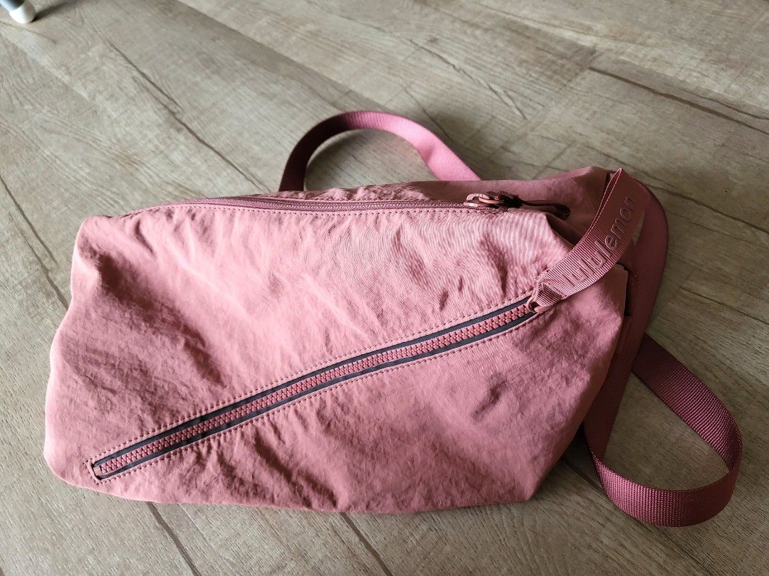 LULULEMON fast track bag 2.0 (Category: Cross-body Bags) located in Singapore. Submitted by sunshineblush_ (Listing ID 1263989196, Image 3). Description: dusty pink. Used only a few times and condition is still good. very slight discolouration on one of the metal clapse but not very obvious. retail price $128.