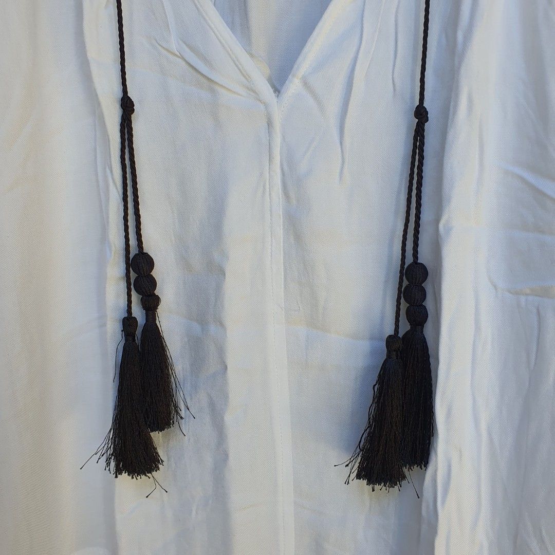 H&M classic white long sleeves blouse (Category: Longsleeves) located in Batangas. Submitted by ghostquire (Listing ID 1264127452, Image 3). Description: features a classic white viscose fabric with black tassel detailing. with extra button. presko fit! best fits s-m for your reference: width (pit to pit) 20” length 26” *needs ironing helping tags: pinterest aesthetic vintage y2k cottagecore coquette gothic academia kawaii grunge egirl indie fair