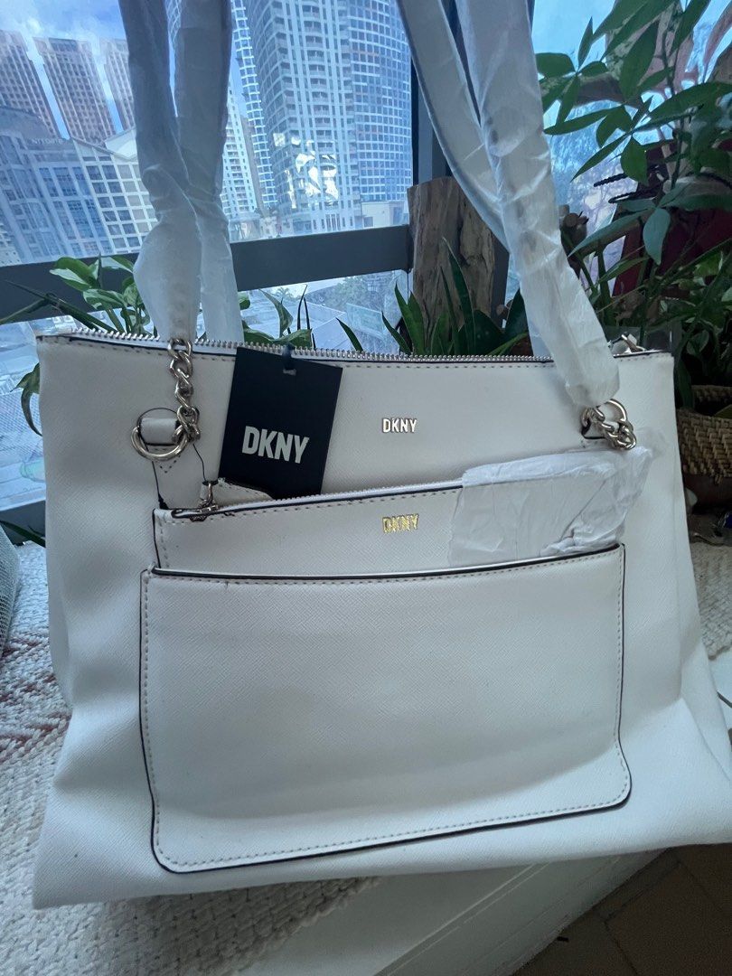DKNY Bryanna Shoulder Bag with Pouch white (Category: Luxury Bags & Wallets) located in Quezon City. Submitted by vianca13 (Listing ID 1272414455, Image 1). Description: DKNY signature Logo to the front. 1 Outer Back Slip Pocket. Inside: 1 Middle Zipper compartment With Two Slip Pockets One Zipper Pocket Shoulder Strap Bag Approximate Bag Size: 13”W X 10’’ H X 5’’ D.