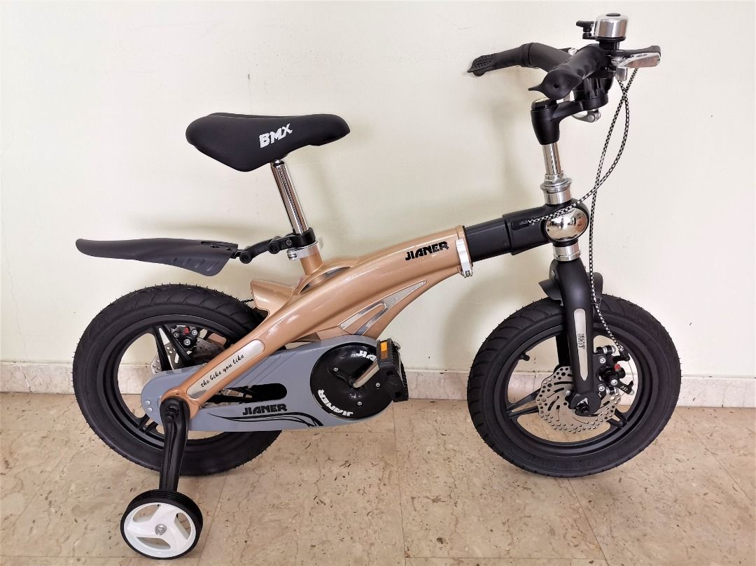 Child Bicycle (PN025) [14 inch Wheel Size] [Retractable Frame] [Foldable Handlebar] [Embedded Clock] (Category: Bicycles) located in Singapore. Submitted by gstrade (Listing ID 1213275574, Image 2). Description: Child Bicycle (PN025) - Free bell, pump, and fender - Color option: gold - Brand new - Single-speed bicycle - Retractable frame - Foldable handlebar - Embedded clock - Double disc brakes - Integrated wheels - Frame material: premium magne