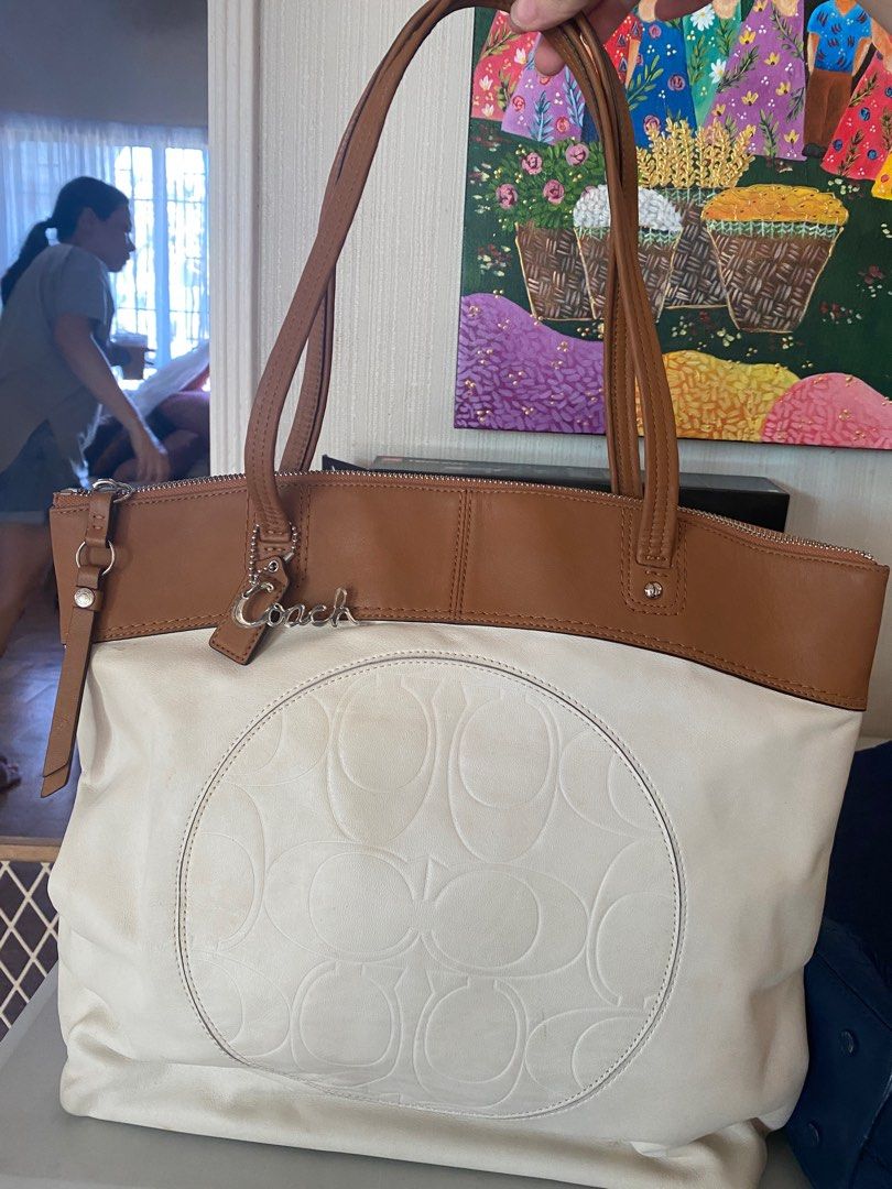 Authentic Coach tote bag (Category: Luxury Bags & Wallets) located in Muntinlupa City. Submitted by plsbuymyclothesplz (Listing ID 1213428345, Image 1). Description: 💌Barely used bought in the US Coach outlet 💌in 9/10 condition, the white lang needs to be cleaned since it was just stored for a few years 💌no flaws on zippers and inside the bag. With dust card pa..