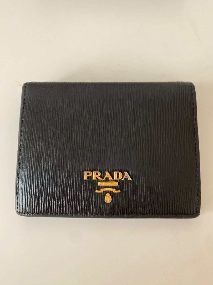 AUTHENTIC PRADA Vitello Move Compact Wallet (Category: Luxury Bags & Wallets) located in Taguig. Submitted by acby.shop (Listing ID 1220209817, Image 2). Description: 100% AUTHENTIC Well-used (condition: 7/10) Color: Nero (black) Usual signs of use/ wear & tear Bought from New York back in 2017 Comes with boxes & authenticity card RFS: Decluttering.