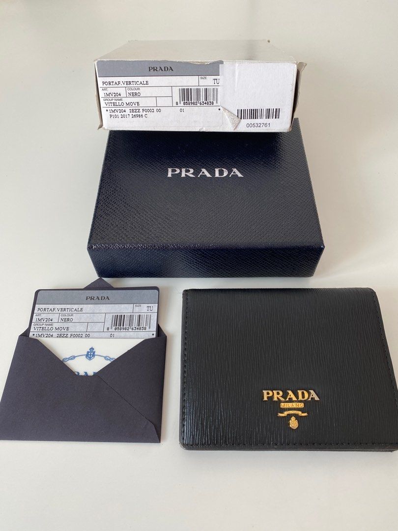AUTHENTIC PRADA Vitello Move Compact Wallet (Category: Luxury Bags & Wallets) located in Taguig. Submitted by acby.shop (Listing ID 1220209817, Image 1). Description: 100% AUTHENTIC Well-used (condition: 7/10) Color: Nero (black) Usual signs of use/ wear & tear Bought from New York back in 2017 Comes with boxes & authenticity card RFS: Decluttering.