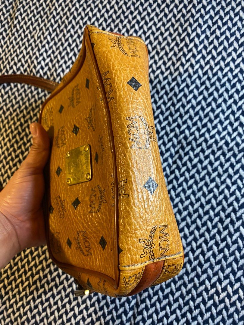 *SALE* Authentic MCM Cognac Camera Sling Bag (Category: Luxury Bags & Wallets) located in Mandaluyong City. Submitted by wear_your_style (Listing ID 1223557849, Image 2). Description: I think this is vintage kasi Munchen nalalagay. In iconic cognac color, matingkad pa. This is a slim type of camera bag measures 6 inches long, 8 inches wide, and with 2 inches depth. Sling is adjustable but not removable. Zippers are good. May zipper compartment sa