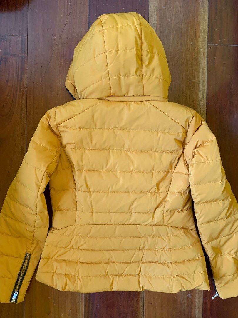 ZARA Women's Puffer Jacket (Category: Coats, Jackets and Outerwear) located in Marikina City. Submitted by raiafr (Listing ID 1219213580, Image 2). Description: Women's puffer jacket from Zara. I remember original price is at P4,000+. Mango yellow color. Size M. Detachable hood. Very soft, fake fur lining inside. Please check ALL photos for defects, nag-crack and disintegrate na yung fake leather along the zippers. Very warm and comfy, I use it e