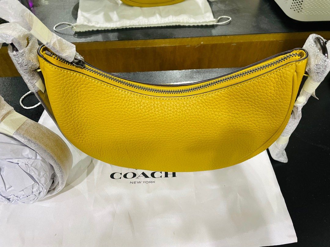 Authentic Coach Luna Shoulder Bag Mustard Yellow (Category: Luxury Bags & Wallets) located in Quezon City. Submitted by selinabu (Listing ID 1226111216, Image 3). Description: Coach reinvents a 1990s-inspired silhouette for SS23, as shown by the Luna bag. Here, the curved-edged accessory is designed in a mustard yellow hue that complements its pebbled calf leather construction and gunmetal-tone hardware. Highlights dark yellow leather grained tex