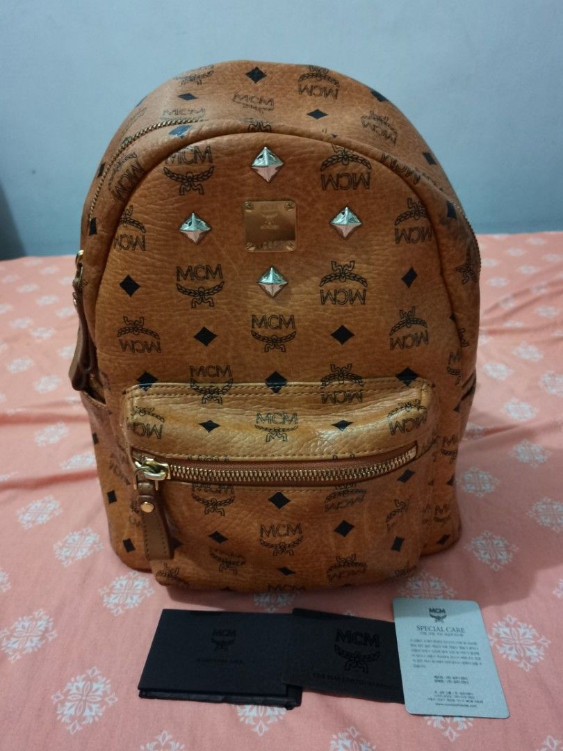 Authentic MCM cognac medium backpack (Category: Luxury Bags & Wallets) located in Dinalupihan. Submitted by hydzsalva (Listing ID 1227360426, Image 1). Description: Selling my original MCM medium backpack cognac. Has minor discoloration on top near handle. edges and inside are ok and no flaws..