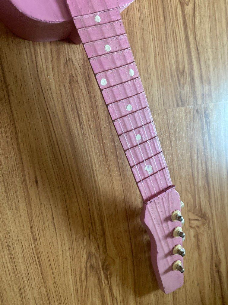 Pink Small guitar Cebu made (Category: Musical Instruments) located in Pasig City. Submitted by marcspade (Listing ID 1224235318, Image 2). Description: Never been used, just displayed, stills works Nylon strings Height - 60 cm Width - max 19 cm.