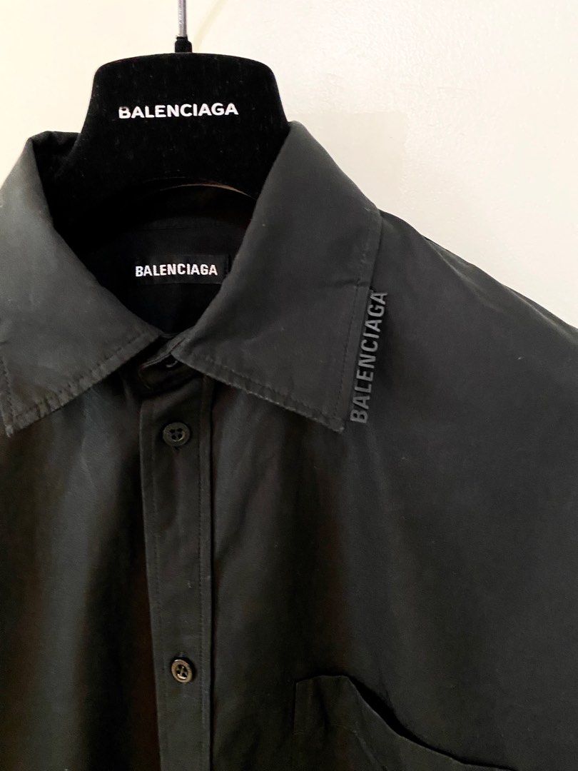 Balenciaga Black Shirt (Category: Luxury Apparel) located in Pasig City. Submitted by capsulecollection (Listing ID 1227598286, Image 1). Description: Balenciaga coated cotton black button down shirt Rubber logo on one side of the collar Boxy fit, wide shoulder .