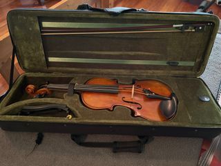 Violin with bow, carrying case, and books