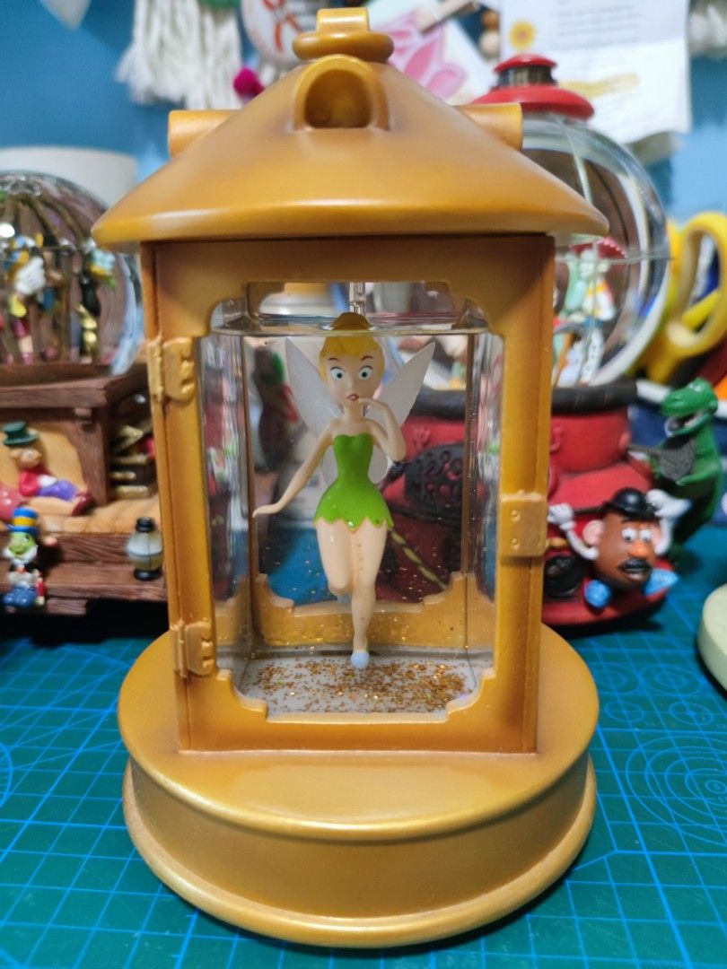 DISNEY Snowglobe Tinkerbell in Lantern (Category: Figurines & Statues) located in Quezon City. Submitted by byseame (Listing ID 1224699767, Image 1). Description: Authentic Disney snow globe. Gold glitter. Base has no damage. Fully functional light, switch at the back. Kept on a shelf with minimal light exposure, in a smoke free and pet free room. Requires AAA batteries, not included in the purchase. Video/additional pictures available upon reque