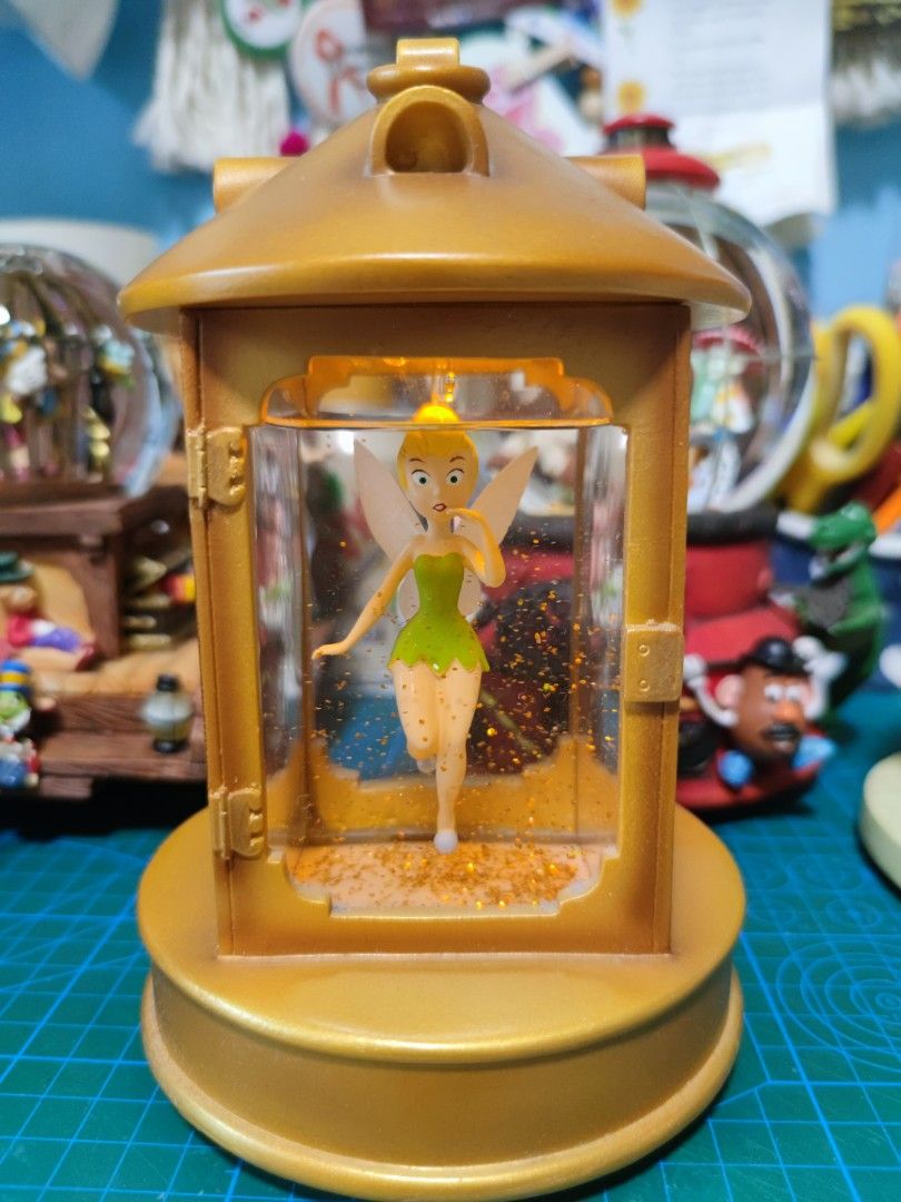 DISNEY Snowglobe Tinkerbell in Lantern (Category: Figurines & Statues) located in Quezon City. Submitted by byseame (Listing ID 1224699767, Image 2). Description: Authentic Disney snow globe. Gold glitter. Base has no damage. Fully functional light, switch at the back. Kept on a shelf with minimal light exposure, in a smoke free and pet free room. Requires AAA batteries, not included in the purchase. Video/additional pictures available upon reque