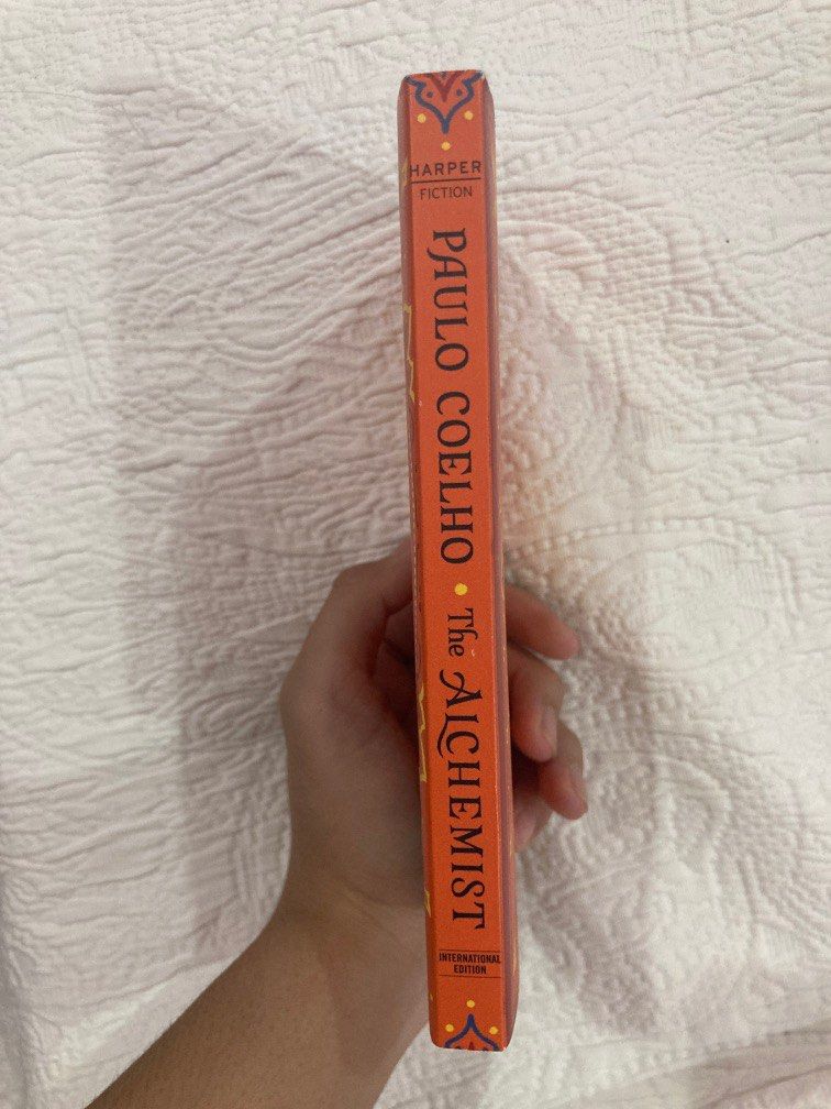 The Alchemist by Paulo Coelho (Category: Storybooks) located in Taguig. Submitted by cluttered.mind (Listing ID 1229617254, Image 3). Description: Never read nor used - dont plan to read it - its just stored - very very minimal flaw which is seen in the last photo - bought from Fully Booked for P399.00 (the tag is still even on it).