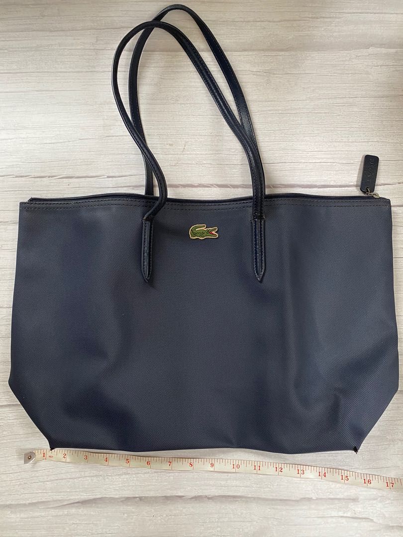 Lacoste (Category: Tote Bags) located in Quezon City. Submitted by 072500 (Listing ID 1234492542, Image 3). Description: Lac0ste bag with zipper in navy blue -P590 -Two large handles and an inside zippered pocket on this tote bag -in elegant navy blue color -Preloved -From Lacoste boutique in estancia -size is big enough to be overnight bag/shopping bag.