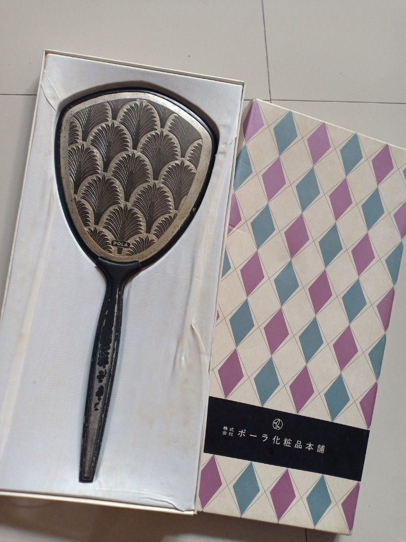 Vintage Vanity Hand Mirror (Category: Makeup) located in Binangonan. Submitted by stufflikedat (Listing ID 1230358399, Image 2). Description: Vintage 1960's Pola Cosmetics (Japan) vanity hand mirror in very good condition with original box,it is made of heavy metal and has a small Pola stamp, handle made of tin metaal, the wavy peacock-like pattern is also grand and elegant. Made In Japan Crica : 1960's Size : Mirror : 34cm x 14cm Mirror in prist