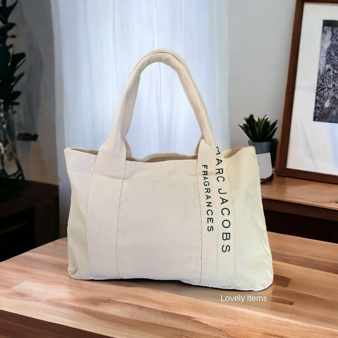 VIP GIFT ITEMS (Category: Luxury Bags & Wallets) located in Orani. Submitted by lovely.items1983 (Listing ID 1230486747, Image 1). Description: Minimalist Marc Jacobs Perfume Tote Material: Canvas Lining texture: polyester Pattern: Letters Color: beige The handle of the bag is 16 cm long. Canvas bag, primary color, strong, large capacity, can hold a lot of things. Open bag style, no extra pocket inside, can hold A4 documents or laptop. Can be wor