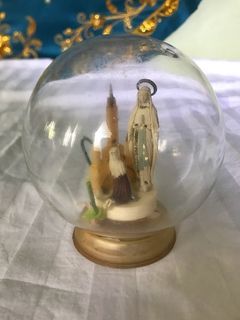 Vintage Statue in Glass Globe Appearance of the Virgin Lourdes pilgrimage France souvenir. Retro kitsch altar decoration praying shrine