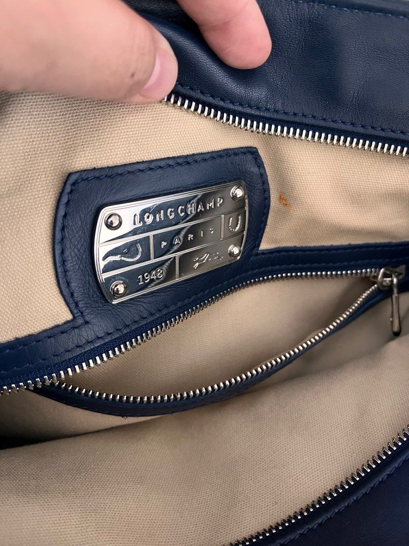 Longchamp tote cuir blue leather embossed authentic (Category: Shoulder Bags) located in Makati City. Submitted by loveeph (Listing ID 1238450671, Image 3). Description: Longchamp leather cuir tote bag with zipper closure medium size Blue color with Silver tone hardware Guaranteed authentic with care card With decorative silver tag No dust bag Fabric interior. Slight makeup stain near interior zipper (see photo #3) With two strap handles, adjusta