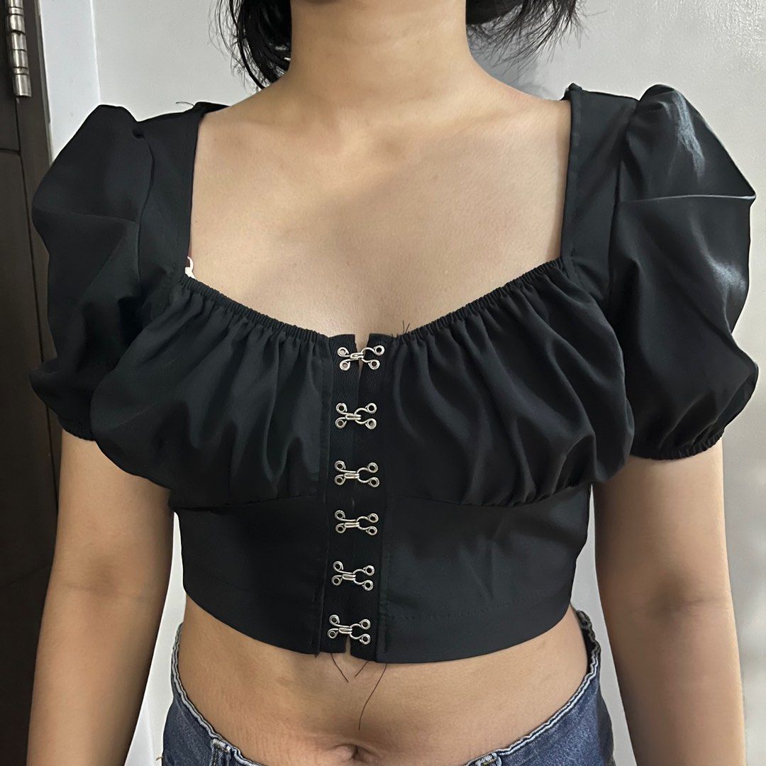 Shein black blouse top with puff sleeves (Category: Blouses) located in Taytay. Submitted by mimiccart (Listing ID 1239864173, Image 1). Description: fits S to M, black crop blouse, great for clubbing and parties, secured by front clasps and with garter ang sleeves. Brand: shein mod: jnt, ggx, sco, llmove pm me for price nego!.