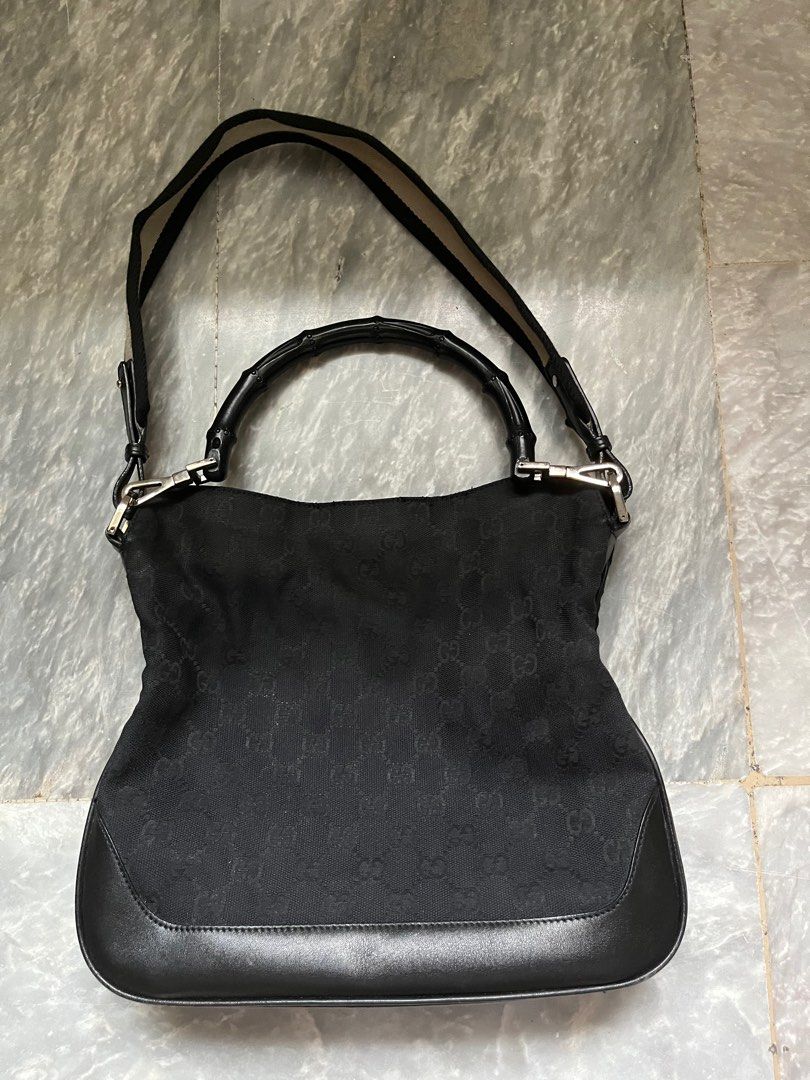 Authentic Black Gucci Bamboo Handle Bag (Category: Luxury Bags & Wallets) located in Paranaque City. Submitted by _lexus (Listing ID 1235412779, Image 2). Description: Well loved Gucci bamboo handle bag with strap. - Canvas material with leather bottom - Can be worn as a shoulder bag via bamboo handle or the strap - Silver hardware - Still very nice outside but lining inside is ripped Matches any outfit and is very low maintenance since its black