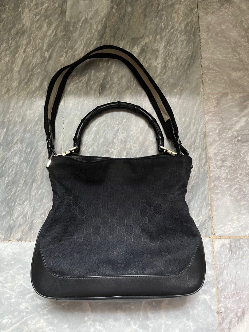 Authentic Black Gucci Bamboo Handle Bag (Category: Luxury Bags & Wallets) located in Paranaque City. Submitted by _lexus (Listing ID 1235412779, Image 1). Description: Well loved Gucci bamboo handle bag with strap. - Canvas material with leather bottom - Can be worn as a shoulder bag via bamboo handle or the strap - Silver hardware - Still very nice outside but lining inside is ripped Matches any outfit and is very low maintenance since its black