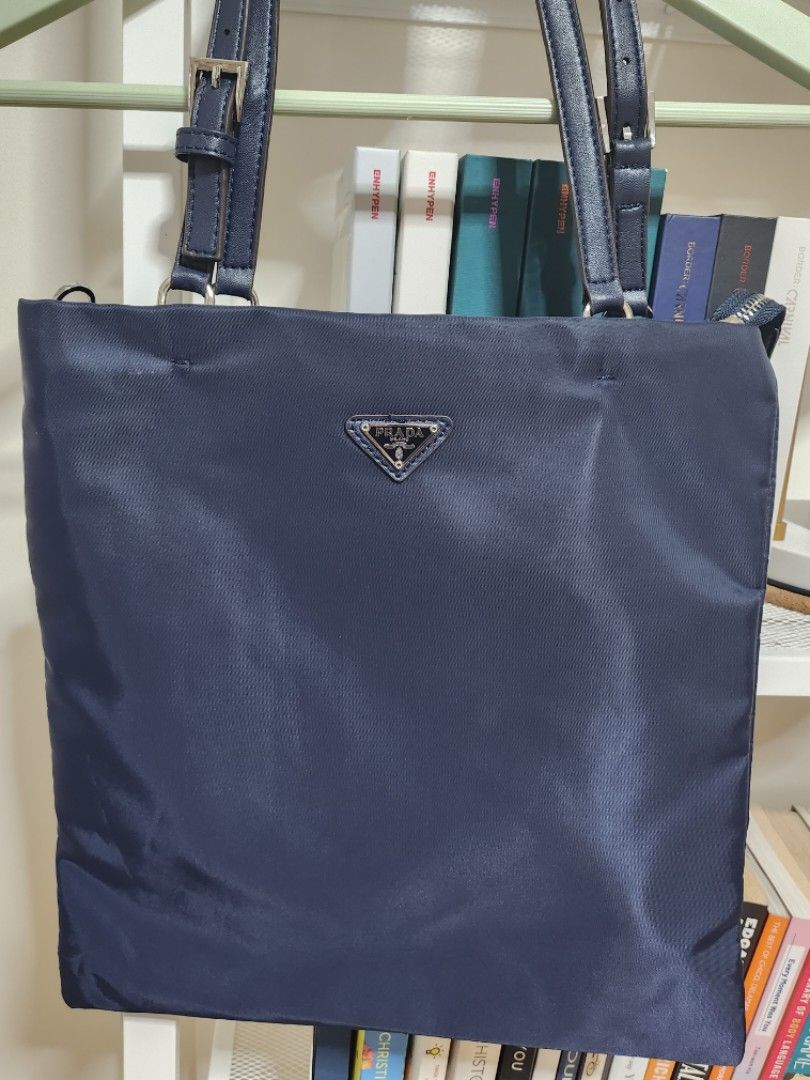 Prada Nylon Tote (Navy Blue) (Category: Luxury Bags & Wallets) located in Manila. Submitted by cloudita (Listing ID 1235653945, Image 1). Description: rfs: my dad has been recently diagnosed with cancer and selling my preloved items to help fund his treatment! ♡ Selling pre-loved topgrade Prada Tote Never used. :) Inclusions are: • Bag • Sling (chain type).