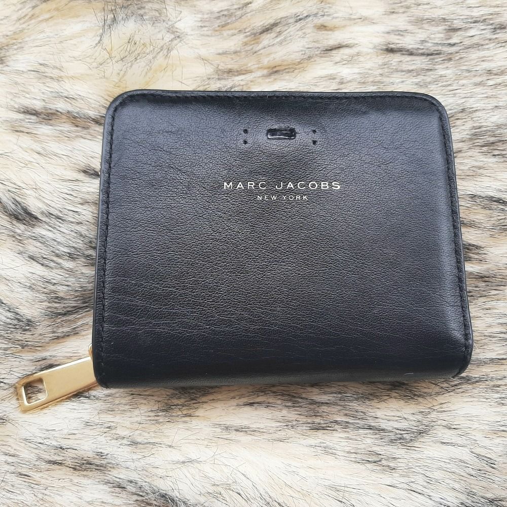 Authentic Marc Jacobs Small Bifold Leather Wallet with Zip Compartment Black Original (Category: Luxury Bags & Wallets) located in Pasig City. Submitted by swing_again_golf (Listing ID 1240489887, Image 1). Description: Brand: Marc Jacobs Genuine Leather Very good condition. Missing metal MJ logo on front (refer to photo). High-quality leatherware. 8 card slots Zip compartment for coins One bill compartment Snap closure.