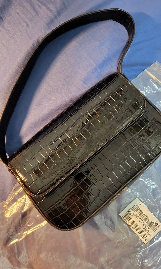 Preloved H&M Croc Embossed Shoulder Bag (Category: Shoulder Bags) located in Pasig City. Submitted by ces013 (Listing ID 1245359881, Image 1). Description: Small shoulder bag in grained imitation leather with a short shoulder strap and a flap with a magnetic fastener. Lined. Width 22.5 cm. Height 12.5 cm. Depth 4 cm. Weight: 211 g Accessory Style: Shoulder bag Description: Black, Crocodile-patterned Concept: DIVIDED Originally priced at PHP 799 a