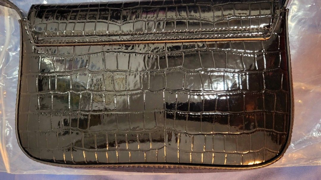 Preloved H&M Croc Embossed Shoulder Bag (Category: Shoulder Bags) located in Pasig City. Submitted by ces013 (Listing ID 1245359881, Image 3). Description: Small shoulder bag in grained imitation leather with a short shoulder strap and a flap with a magnetic fastener. Lined. Width 22.5 cm. Height 12.5 cm. Depth 4 cm. Weight: 211 g Accessory Style: Shoulder bag Description: Black, Crocodile-patterned Concept: DIVIDED Originally priced at PHP 799 a