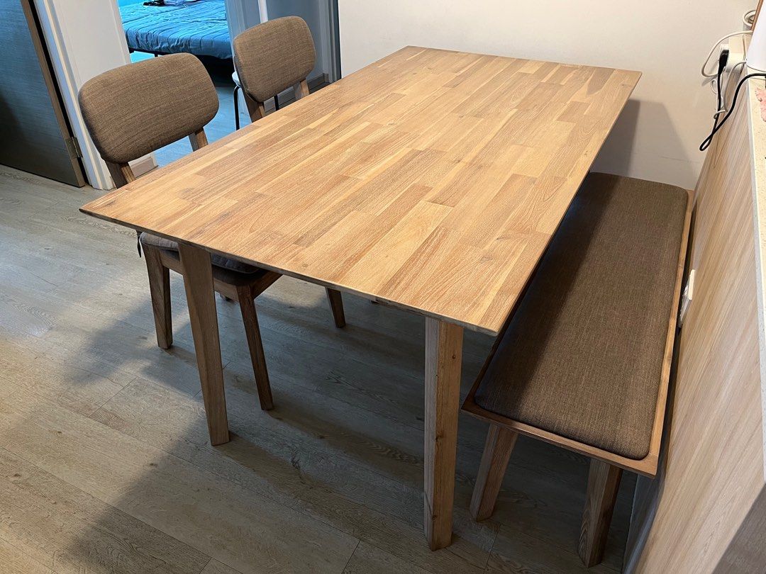 Solid Wood Dining Table Set (Category: Tables & Sets) located in Singapore. Submitted by gwunsss (Listing ID 1241045318, Image 2). Description: 4-piece Dining Table Set - Solid acacia wood in very good condition (9.5/10) - water-resistant and scratch-resistant *DINING TABLE SET* - Dining table 1.6m (w) x 90cm (d) x 76cm (h) - Bench 1.3m (w) x 37cm (d) x 45cm (h) - 2 chairs with padded cushion and fabric upholstery 42cm (w) x 40cm (d) x 48cm (seat