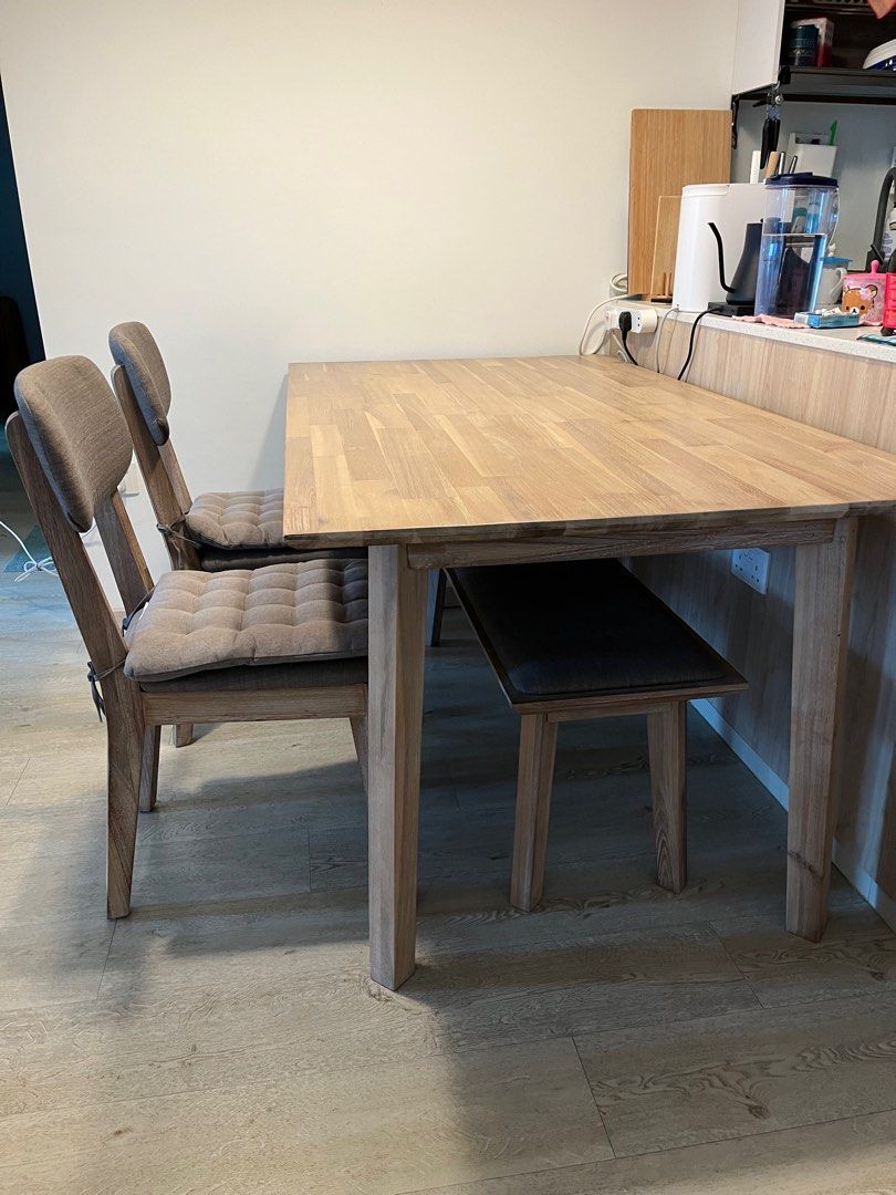Solid Wood Dining Table Set (Category: Tables & Sets) located in Singapore. Submitted by gwunsss (Listing ID 1241045318, Image 3). Description: 4-piece Dining Table Set - Solid acacia wood in very good condition (9.5/10) - water-resistant and scratch-resistant *DINING TABLE SET* - Dining table 1.6m (w) x 90cm (d) x 76cm (h) - Bench 1.3m (w) x 37cm (d) x 45cm (h) - 2 chairs with padded cushion and fabric upholstery 42cm (w) x 40cm (d) x 48cm (seat