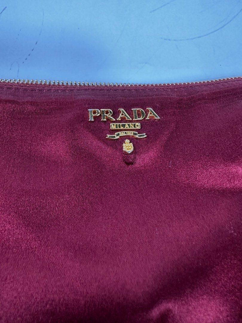 Prada Silk Pouch (Category: Luxury Bags & Wallets) located in Quezon City. Submitted by mygaragesale.ph (Listing ID 1246456852, Image 2). Description: Prada Silk Pouch Wine red. pls see photo clearly, it has some threadbare on the side and on the front logo. No dustbag. Guaranteed authentic. .